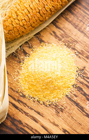 Corn groats and seeds, corncobs on wooden rustic table Stock Photo
