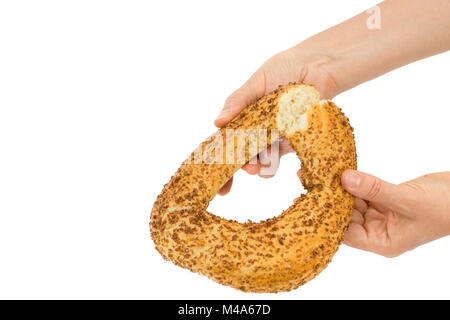Female hands breaks a bagel, isolated on white background Stock Photo