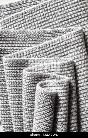 Draped melange gray woolen knitted fabric as background. Stock Photo