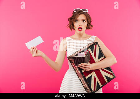 Portrait of a surprised girl dressed in black dress holding stack of ...