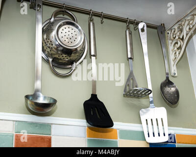 Kitchen Utensils hung up in a country cottage kitchen Stock Photo