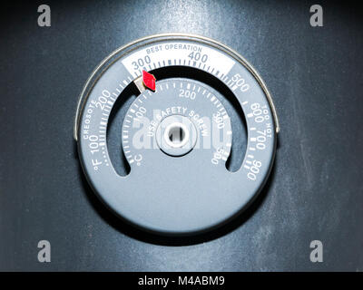 Thermostat for stove fan, on a wood burning stove's flue Stock Photo