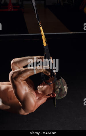 TRX training. Crossfit instructor at the gym doing TRX Excersise. Stock Photo