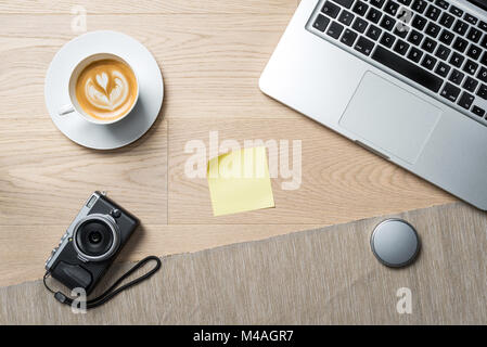 Blank sticky note with copy space for writing a message lying on photographer office desk as flat lay from bird's eye view Stock Photo