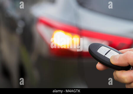 Close Up Of Driver Activating Car Security System With Key Fob Stock Photo