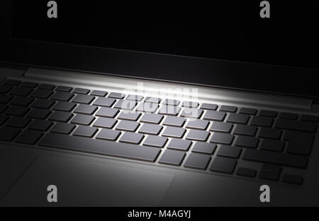 Data and cyber security threat concept. Online financial crime, identity theft and internet scam. Laptop computer keyboard in spotlight. Stock Photo