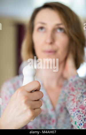 Mature Woman Experiencing Hot Flush From Menopause Using Electric Fan Stock Photo