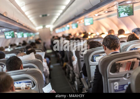 Interior of airplane with passengers on seats waiting to taik off. Stock Photo