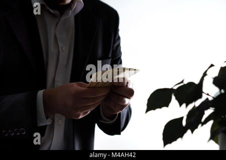 Money laundry, bribery and greediness concept. Businessman or man in a suit holding a stack of money in hand. Stock Photo