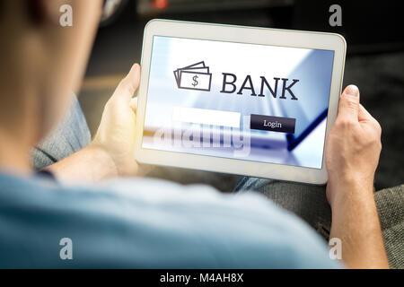 Man using mobile bank application with tablet and smart device at home. Login page to personal account. Online internet banking. Stock Photo
