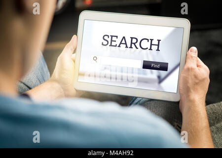 Search engine app on tablet screen. Man trying to find website or service from application with smart mobile device. Stock Photo