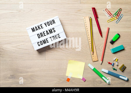 Make your dreams come true writing in lightbox with pen, pencil, highlighter and ruler lying on office desk as flat lay Stock Photo