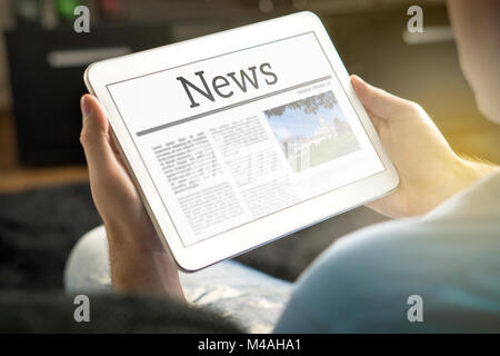 Man reading the news on tablet at home. Imaginary online and mobile news website, application or portal on modern touch screen display. Stock Photo