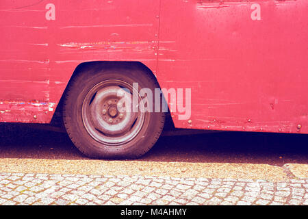 red scratched vintage bus fragment with focus on wheel Stock Photo
