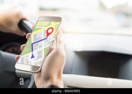 Navigation with mobile app in smartphone. Online map and GPS application on cellphone screen. Inside view in car to hand holding phone in cockpit. Stock Photo