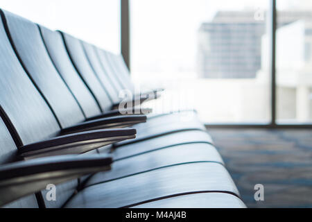 Airport waiting room at terminal. Departure lounge. Empty seats at gate. Light from window. Stock Photo