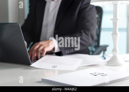 Scale and justice sign on pile of paper. Lawyer working in office. Attorney writing a legal document with laptop computer. Stock Photo