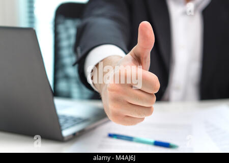 Business man showing thumbs up in office. Stock Photo