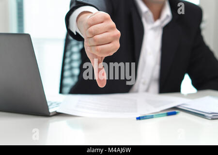 Business man showing thumbs down in office. Stock Photo