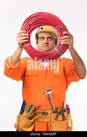 Indian electrician engineer in action with wire cutter, drilling ...