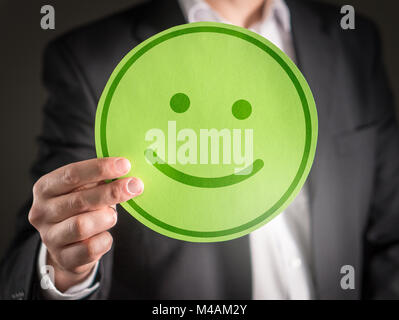Business man with happy cardboard smiley face emoticon. Customer satisfaction or successful business concept. Stock Photo