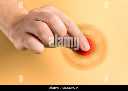 Fidget spinner spinning fast between fingers. Top view. Stock Photo