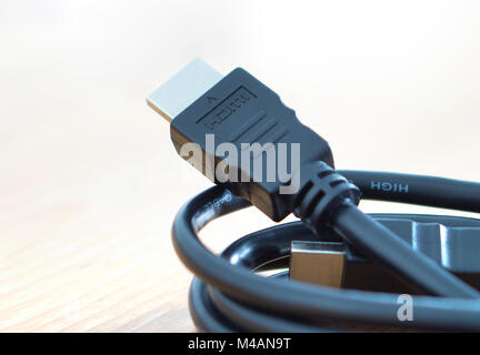 HDMI cable on wooden table at home. Stock Photo