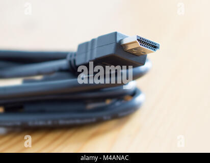 HDMI cable on wooden table at home. Copy space. Stock Photo
