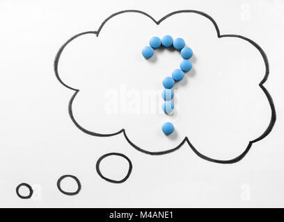 Wondering medical issues or no idea about correct medication or drug. Question mark from pills in thinking speech bubble and thought cloud hand drawn. Stock Photo