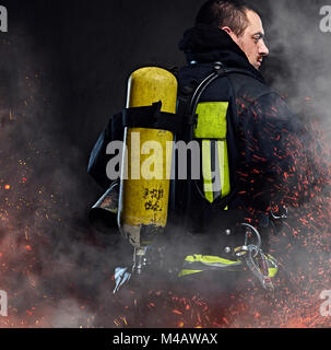 A firefighter dressed in a uniform in a studio. Stock Photo