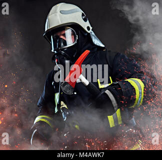 A firefighter dressed in a uniform in a studio. Stock Photo