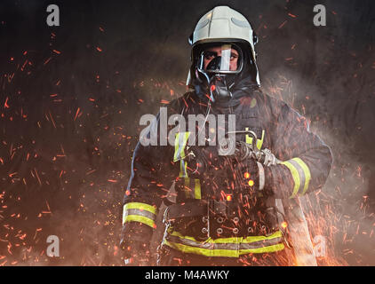 A firefighter dressed in a uniform in a studio. Stock Photo