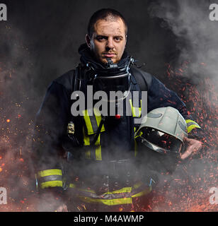 A firefighter dressed in a uniform in a studio. Stock Photo