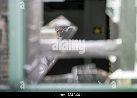 A photographer photographed himself in a broken window pane. Stock Photo