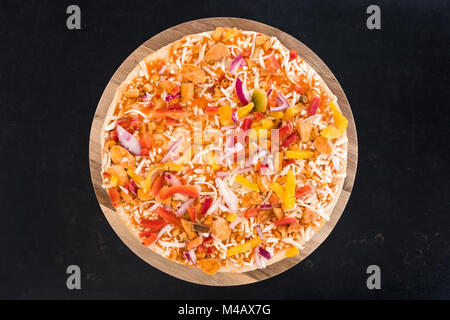Home made chilly chicken pizza on a wooden board ready for the ovan. Stock Photo