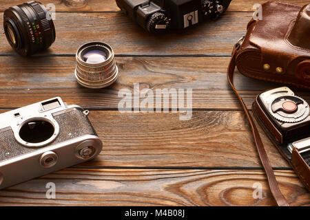 Vintage cameras and lenses on wooden background Stock Photo