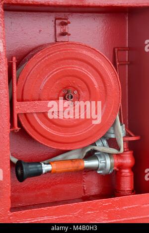 Red fire reel and hose Stock Photo
