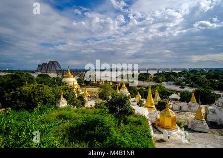 Some of many golden Pagodas on Sagaing Hill, the Yadanabon Bridge crossing the Irrawaddy river in the distance Stock Photo