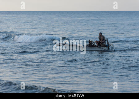 balinese fisherman returns from fishing in the outrigger canoe (Jukung) Stock Photo