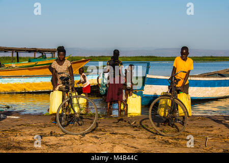 Children filling water in canisters at Lake Albert,Uganda,Africa Stock Photo