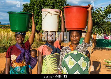 Local women carrying buckets on their heads, Malawi, Africa Stock Photo ...