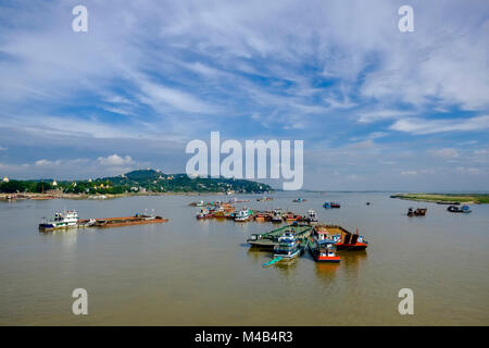 Aerial view from Yadanabon Bridge on boats and ships on the Irrawaddy river, Sagaing Hill in the distance Stock Photo