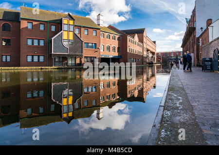 Views of the canal with reflections of people and buildings in Brindley Place Birmingham, UK