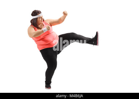 Full length profile shot of an overweight woman kicking isolated on white background Stock Photo