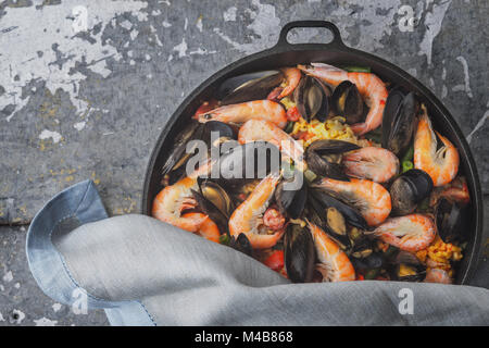 Paella in the pan on the metal background top view Stock Photo