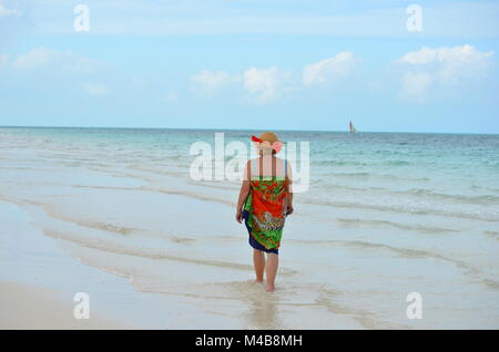 Active senior Caucasian woman on vacation walking on the beach on a tropical Caribbean island (Cayo Coco, Cuba) Stock Photo