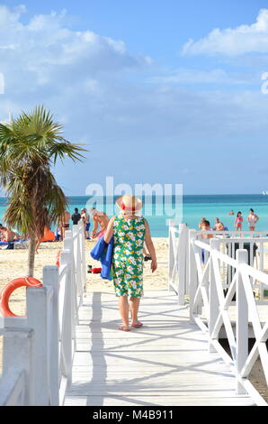 Active senior Caucasian woman on vacation walking on the beach on a tropical Caribbean island (Cayo Coco, Cuba) Stock Photo