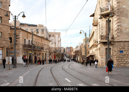 People walk along the Yafo Street tram line in Jerusalem early one winter evening. Stock Photo