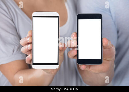 Close-up Of A Couple Showing Blank Cellphone Stock Photo