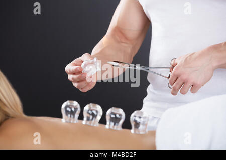 Woman Lying On Front Receiving Cupping Treatment On Back Stock Photo